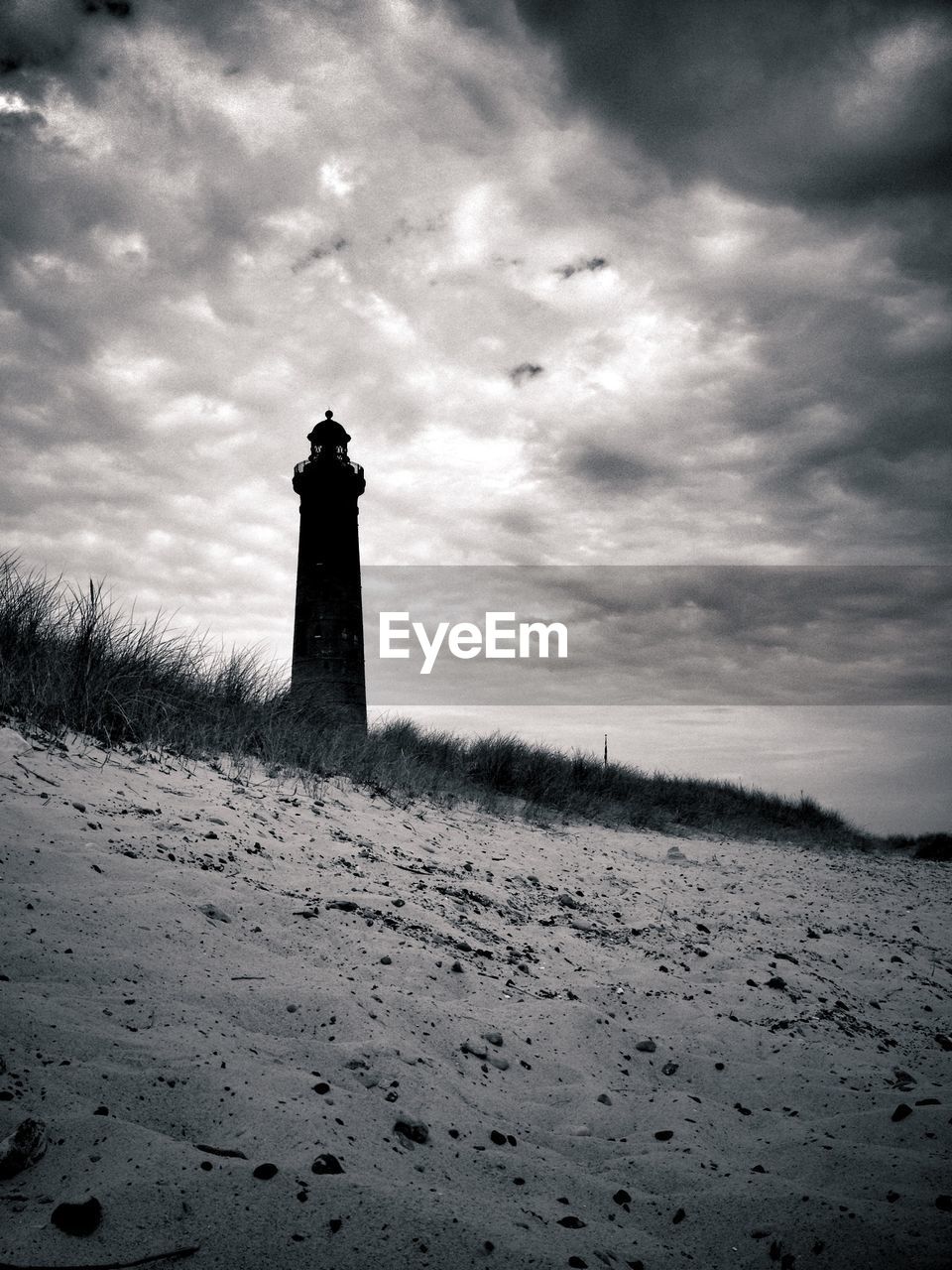 Low angle view of lighthouse against cloudy sky