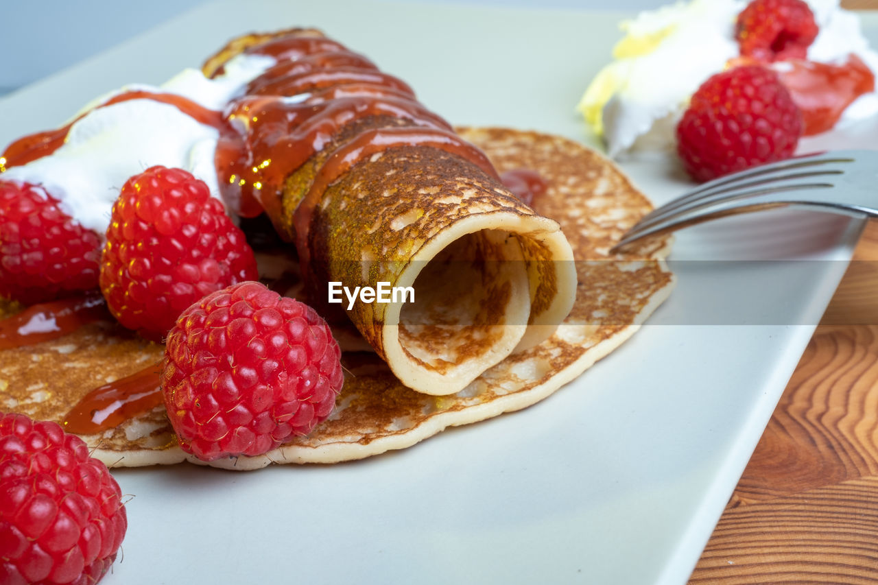 CLOSE-UP OF RASPBERRIES IN PLATE