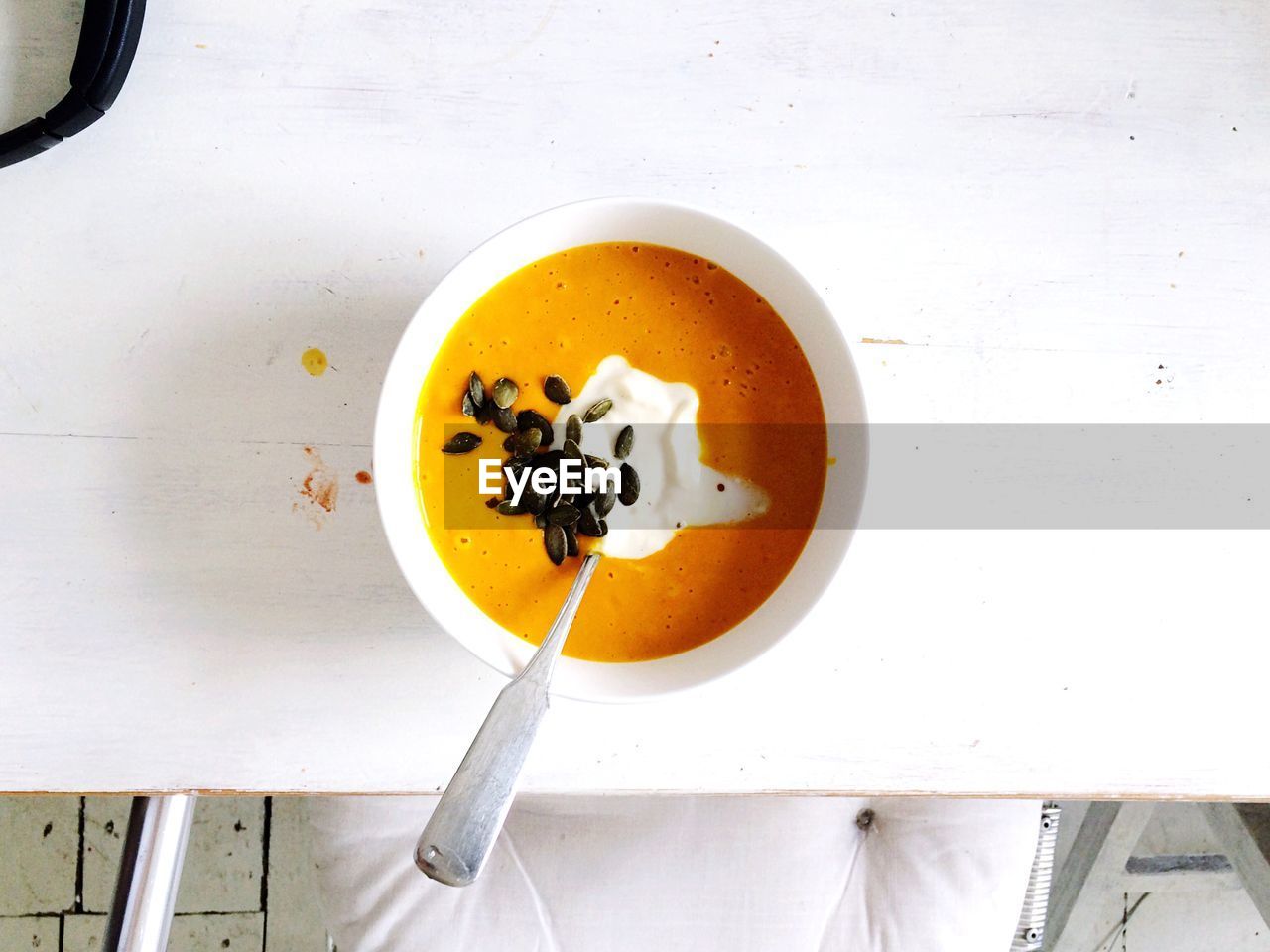 Directly above shot of pumpkin soup in bowl on white table