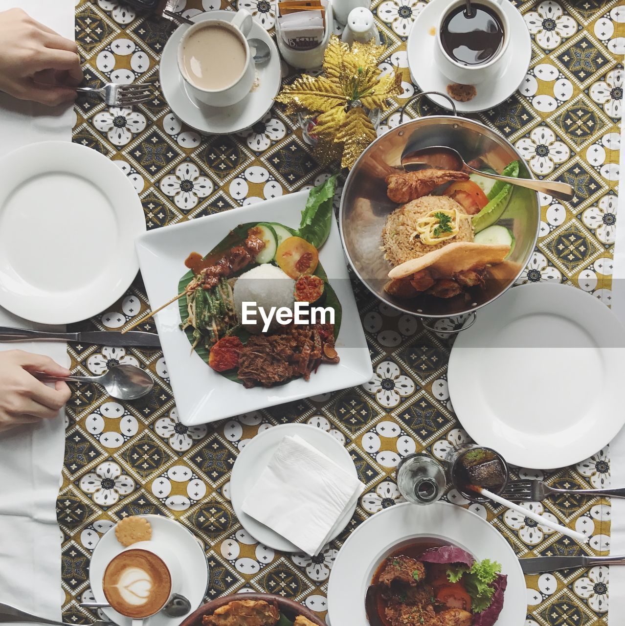 Cropped image of hands with indonesian food at table