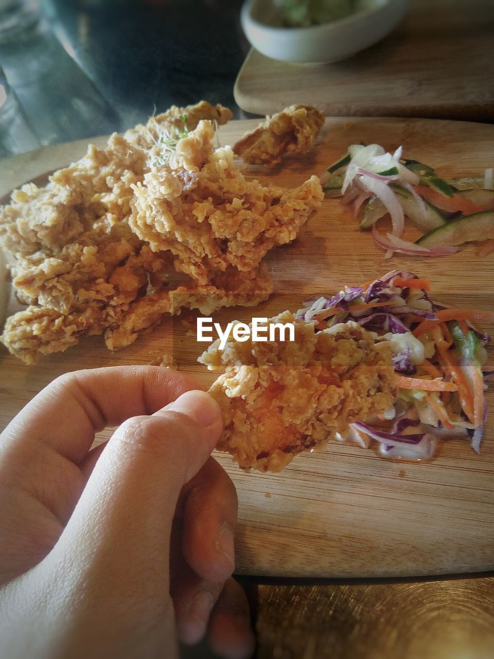 CLOSE-UP OF HAND HOLDING BREAD