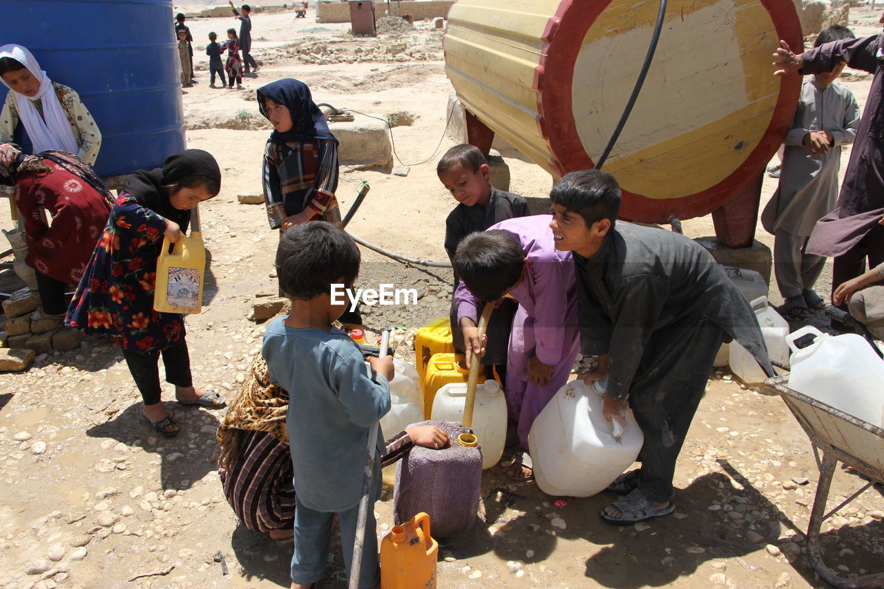 Displaced afghan children collecting water