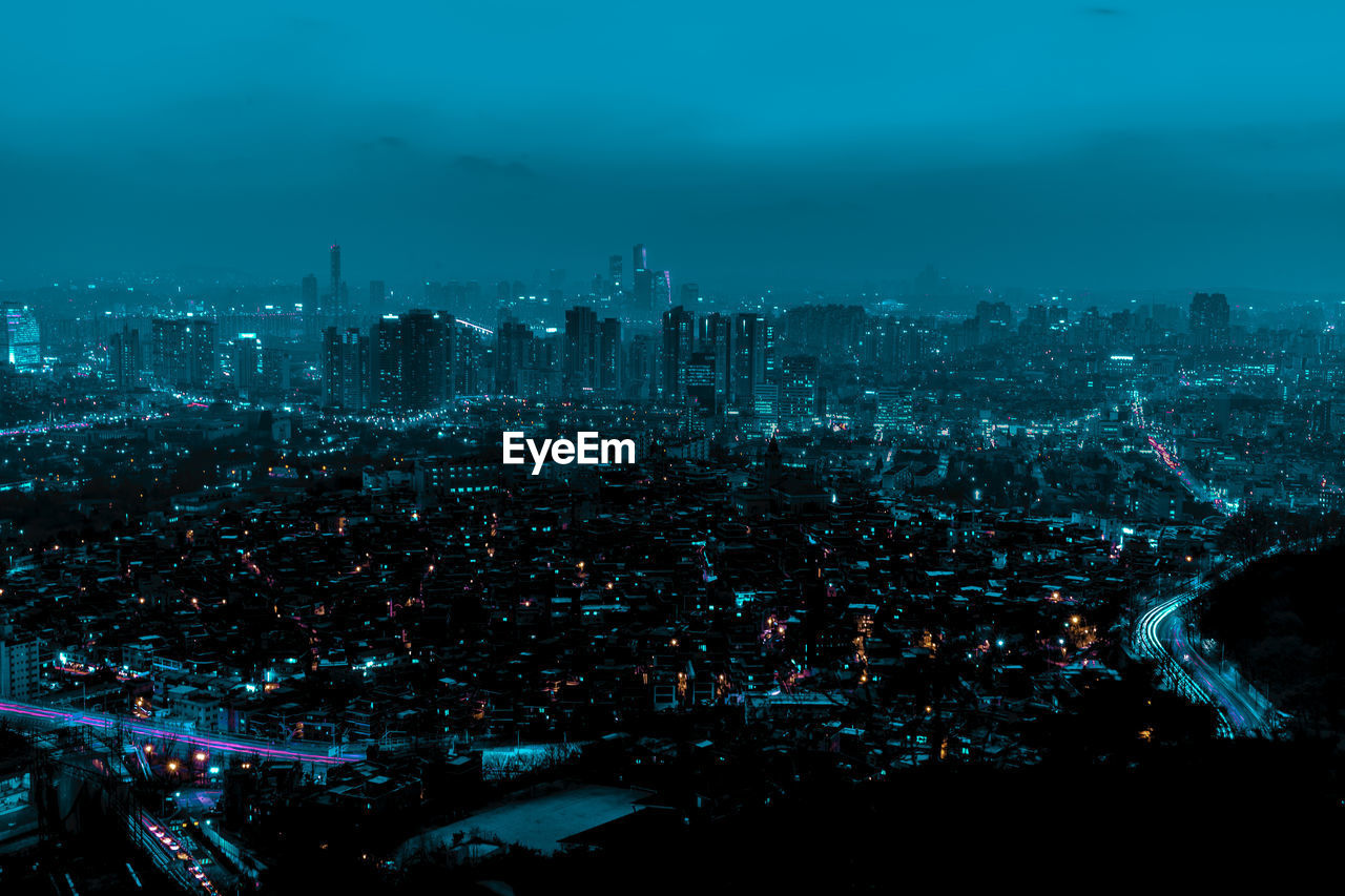 Aerial view of illuminated cityscape against sky at night