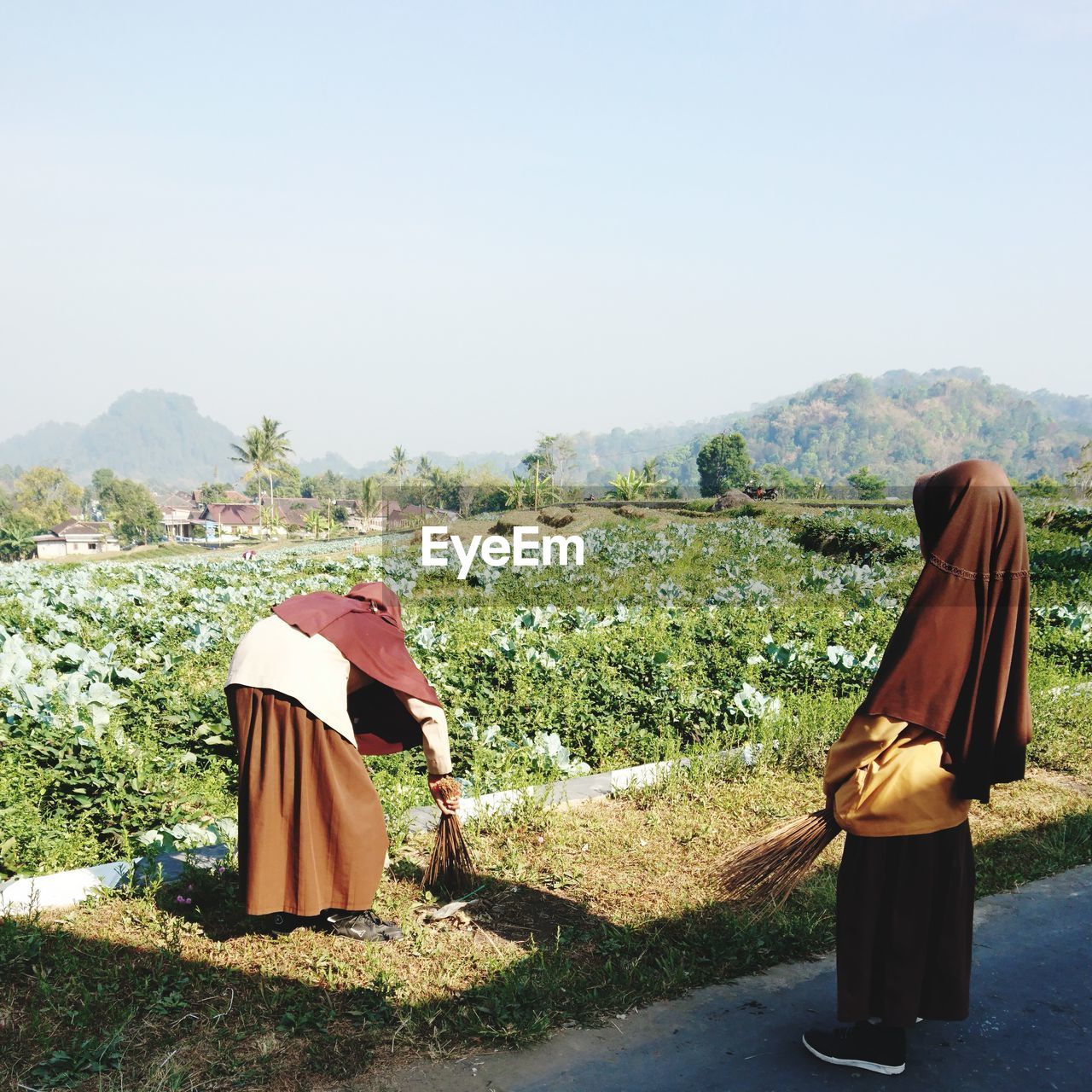 Rear view of woman on field against clear sky