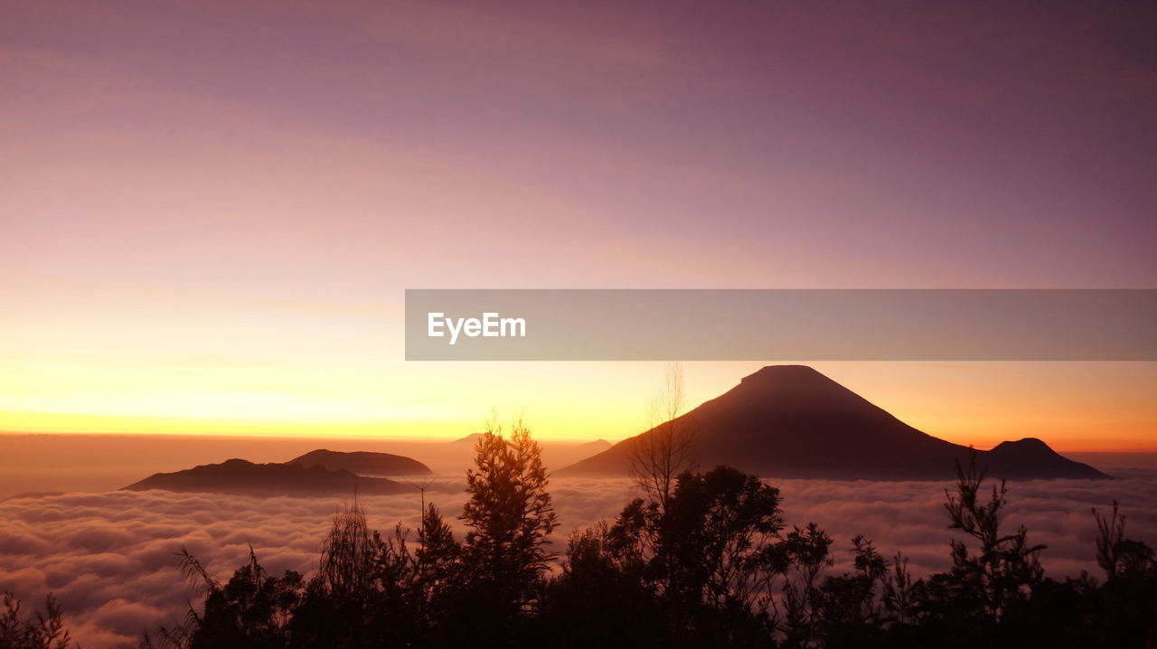 Scenic view of silhouette mountains against orange sky