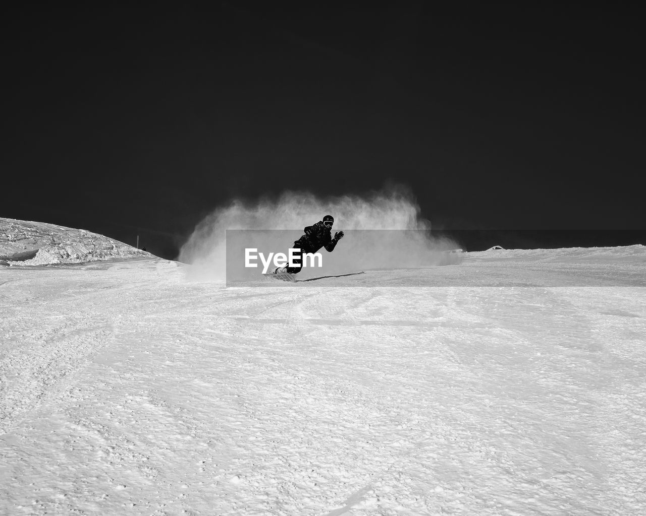 Man snowboarding on snowy land against clear sky