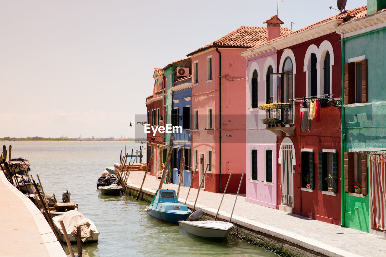 Buildings by sea against sky