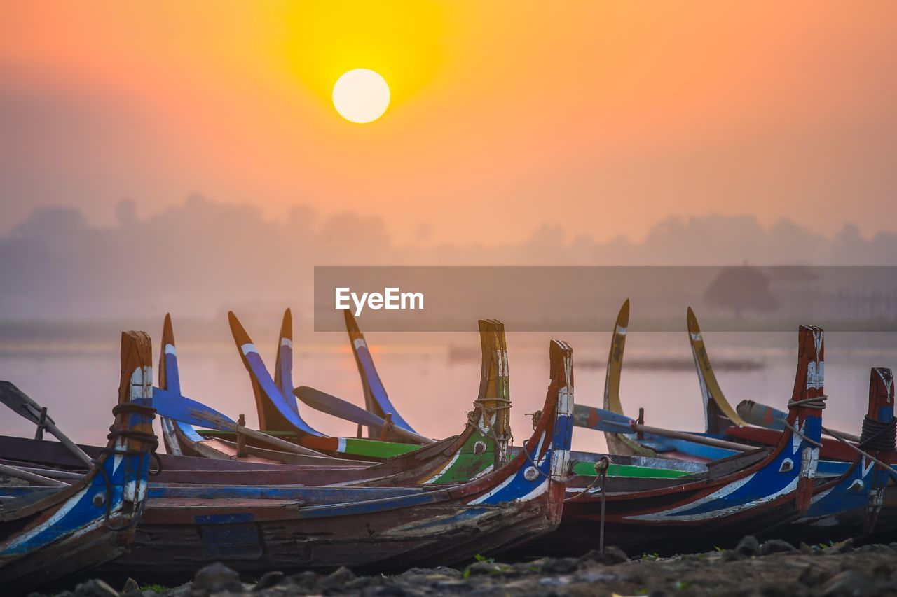Colorful boats on the shore with surise near u bein bridge, myanmar 