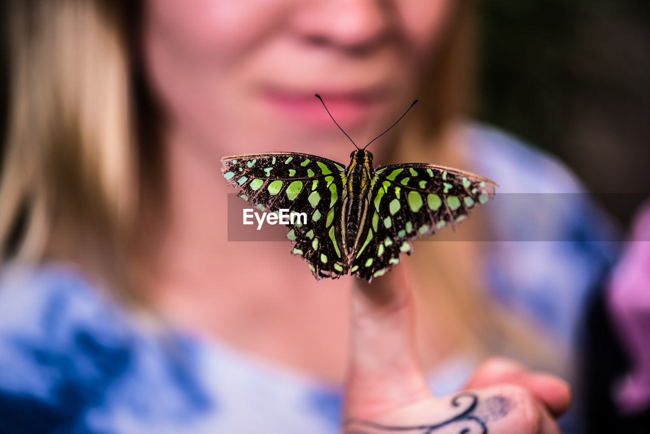 Close-up of woman with butterfly