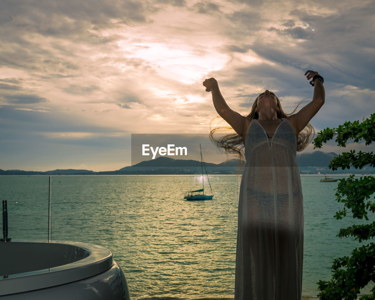 Woman standing against sea during sunset