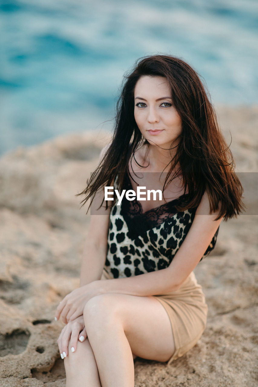 Portrait of a beautiful young woman sitting on beach