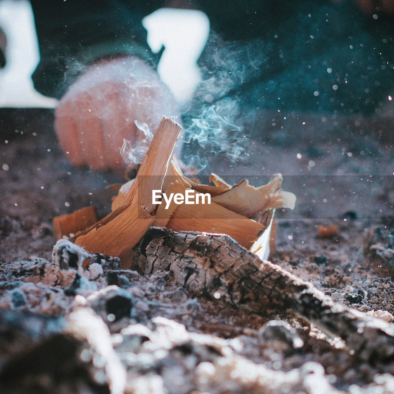 Cropped hand by burning wood