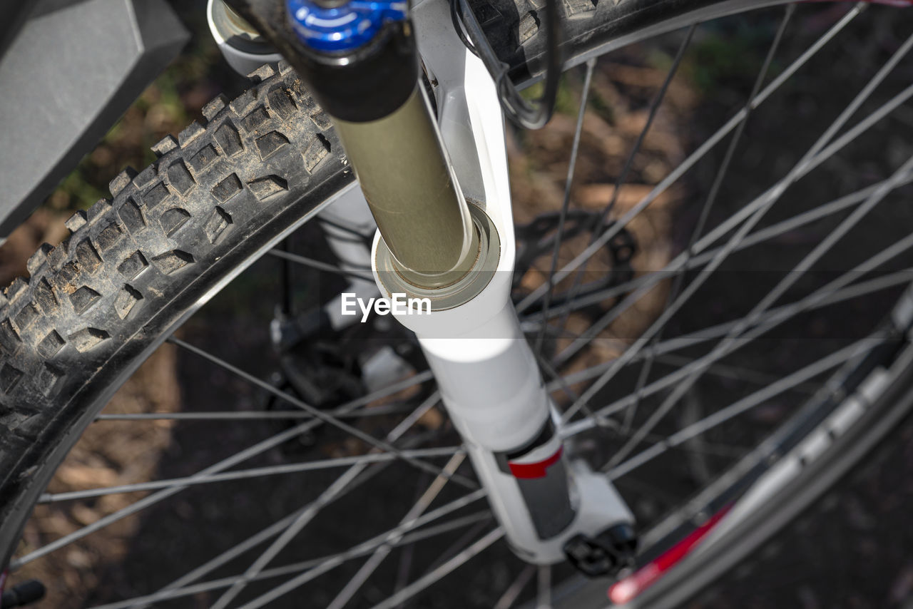 HIGH ANGLE VIEW OF BICYCLE PARKED BY METAL