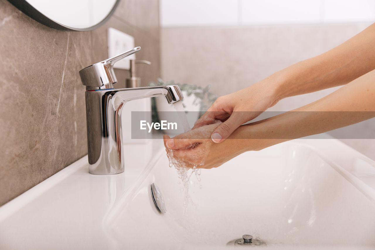 Washing hands under the flowing water tap. hygiene concept hand detail. 