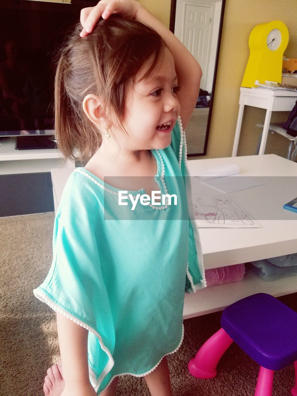 Smiling girl looking away while standing at home