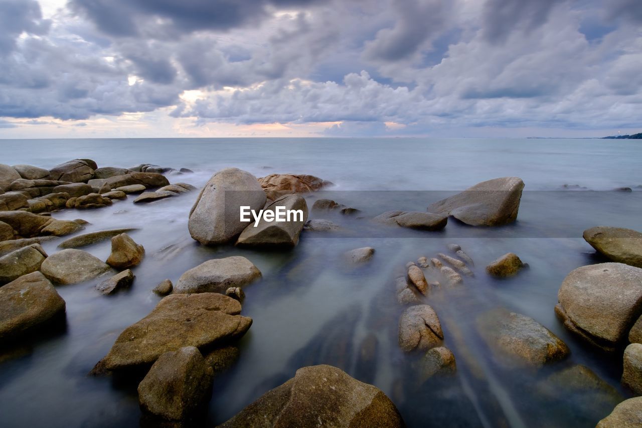 Rocks on beach against sky