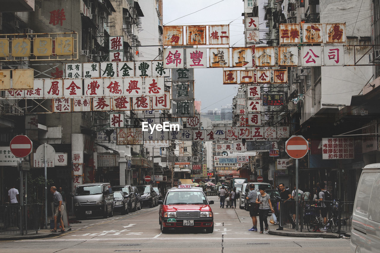 VEHICLES ON ROAD ALONG BUILDINGS