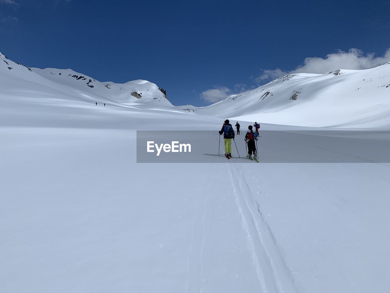 People skiing on snowcapped mountain against sky