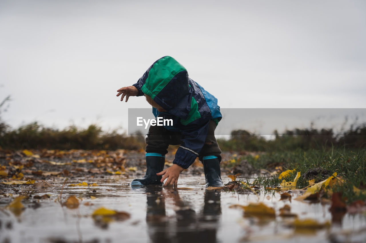 Side view of man standing in puddle