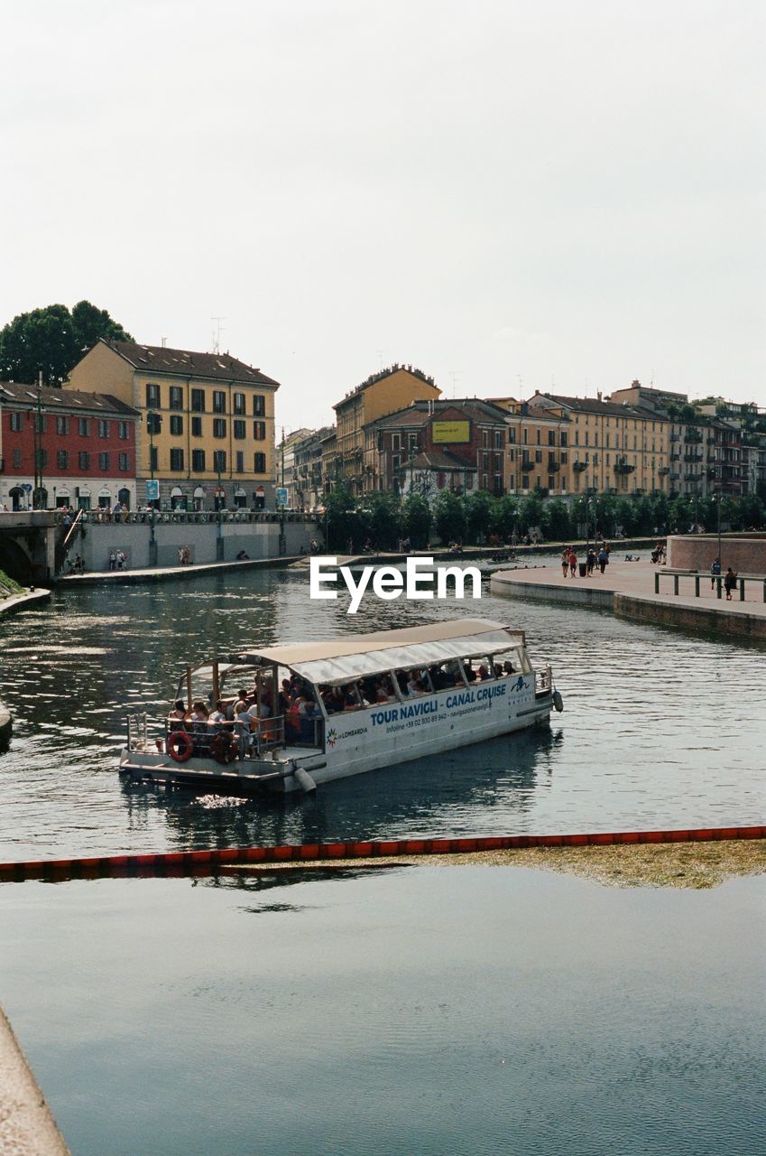 River by buildings in city against clear sky