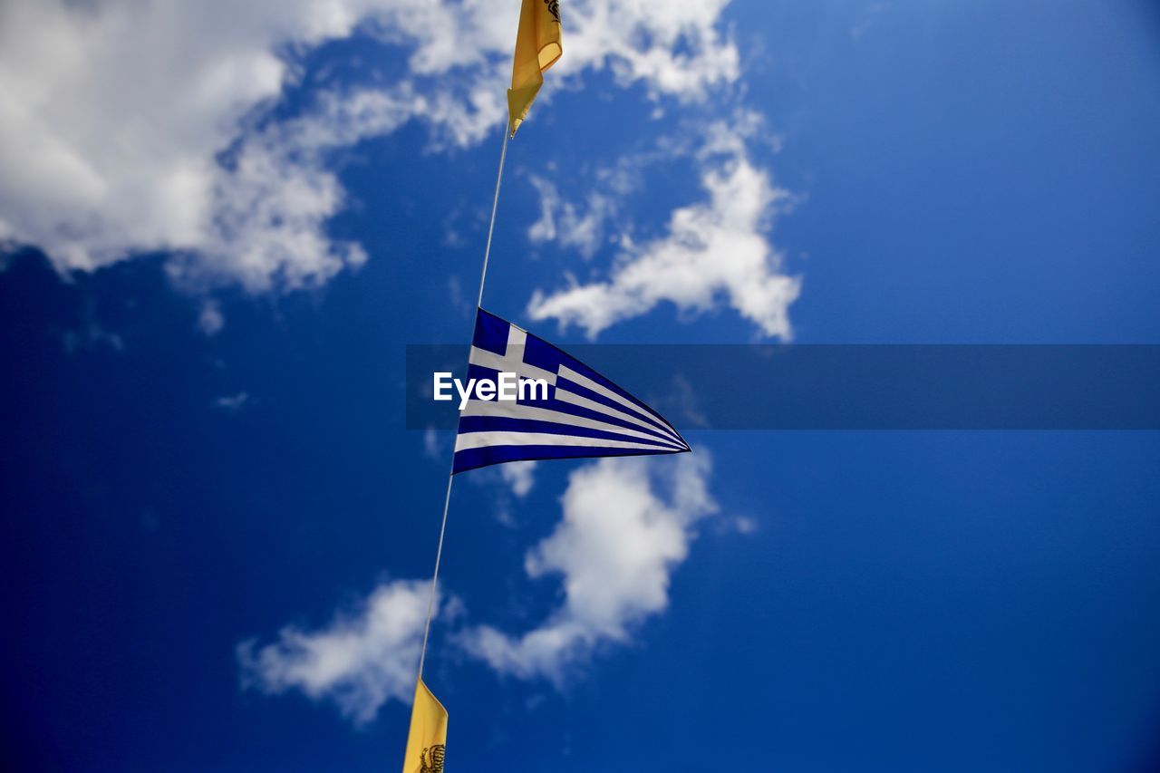 Low angle view of flag against blue sky