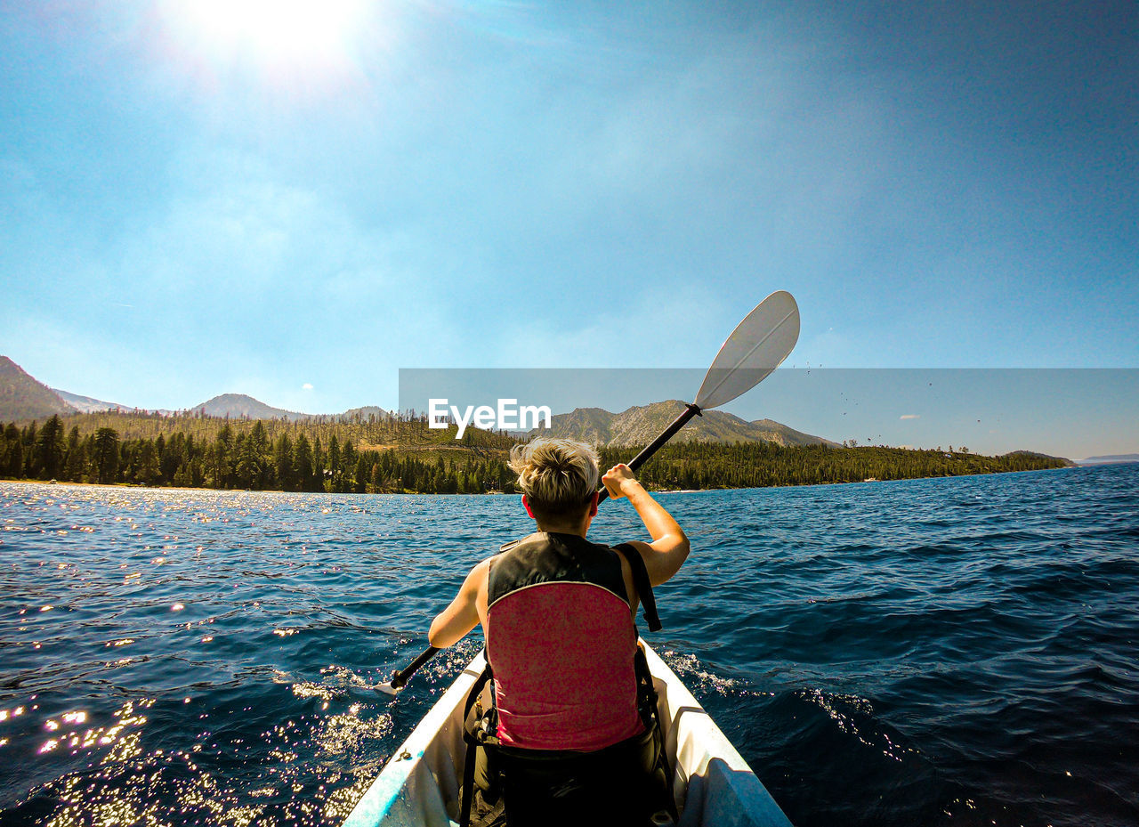 Rear view of woman on boat in sea against sky