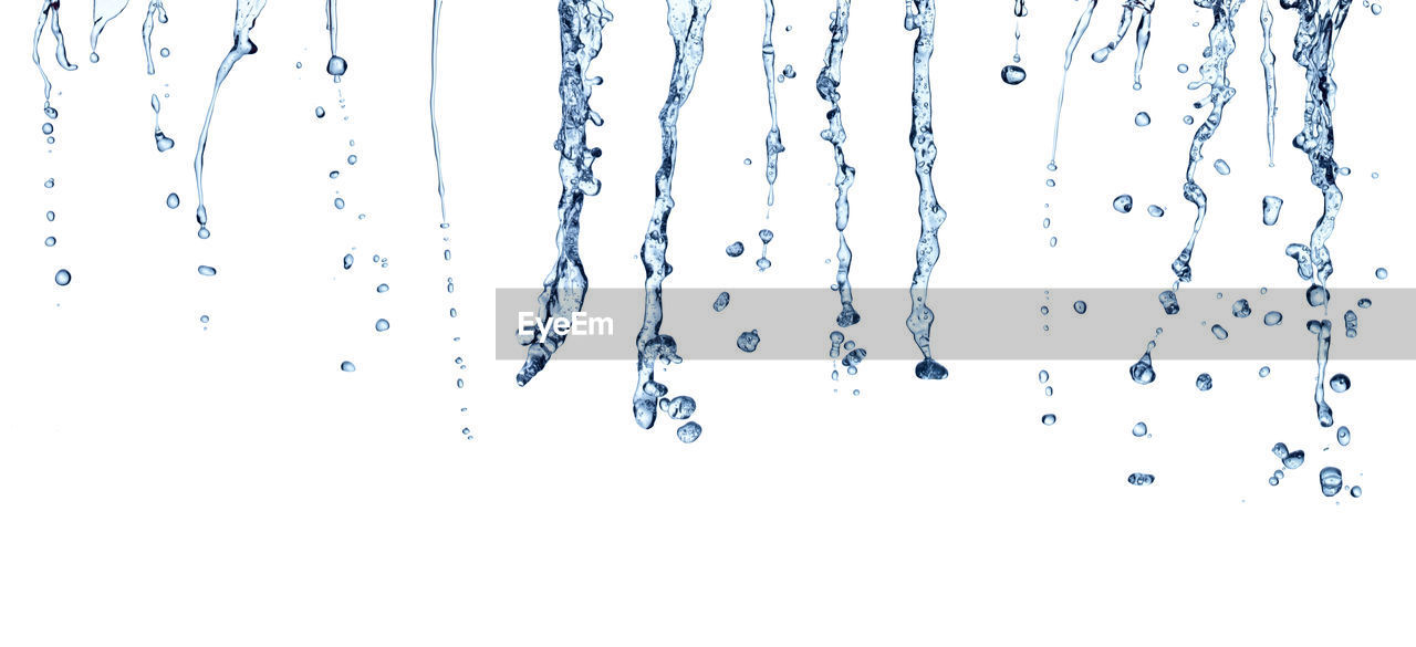 CLOSE-UP OF WATER SPLASHING AGAINST GRAY BACKGROUND