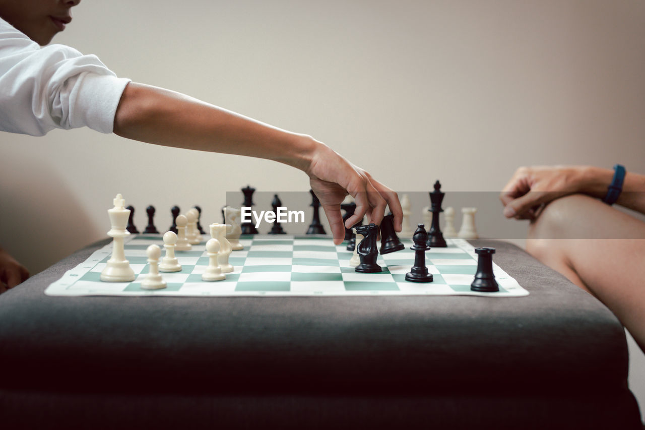 Cropped hand of young man playing chess