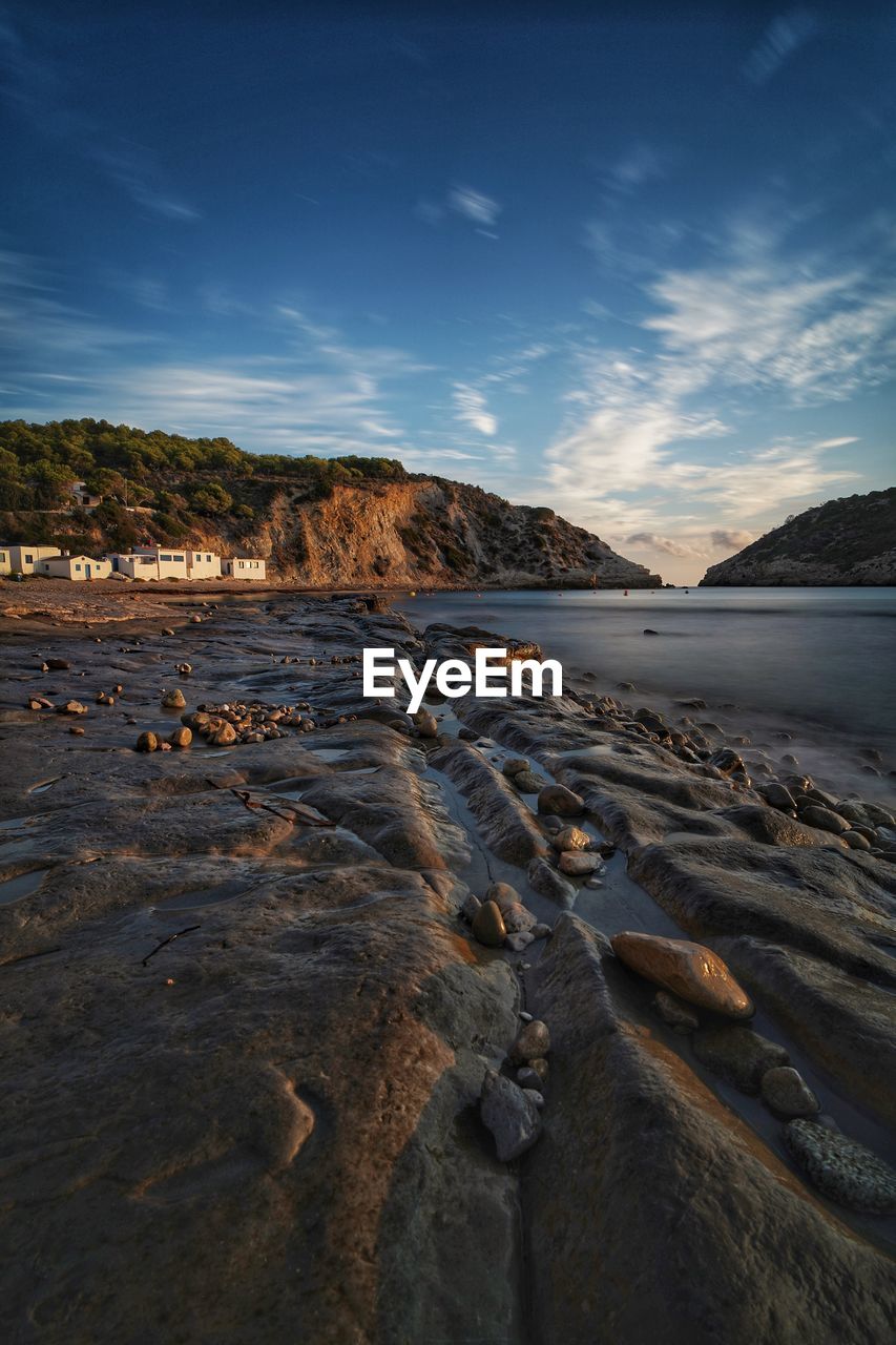 Surface level of rocks on beach against sky