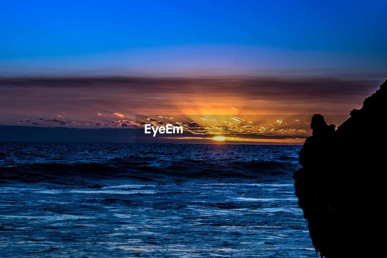 SCENIC VIEW OF SEA AGAINST ORANGE SKY