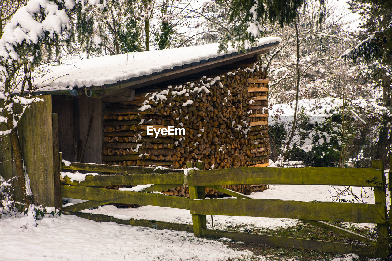 SNOW COVERED FIELD BY TREES AND BUILDINGS