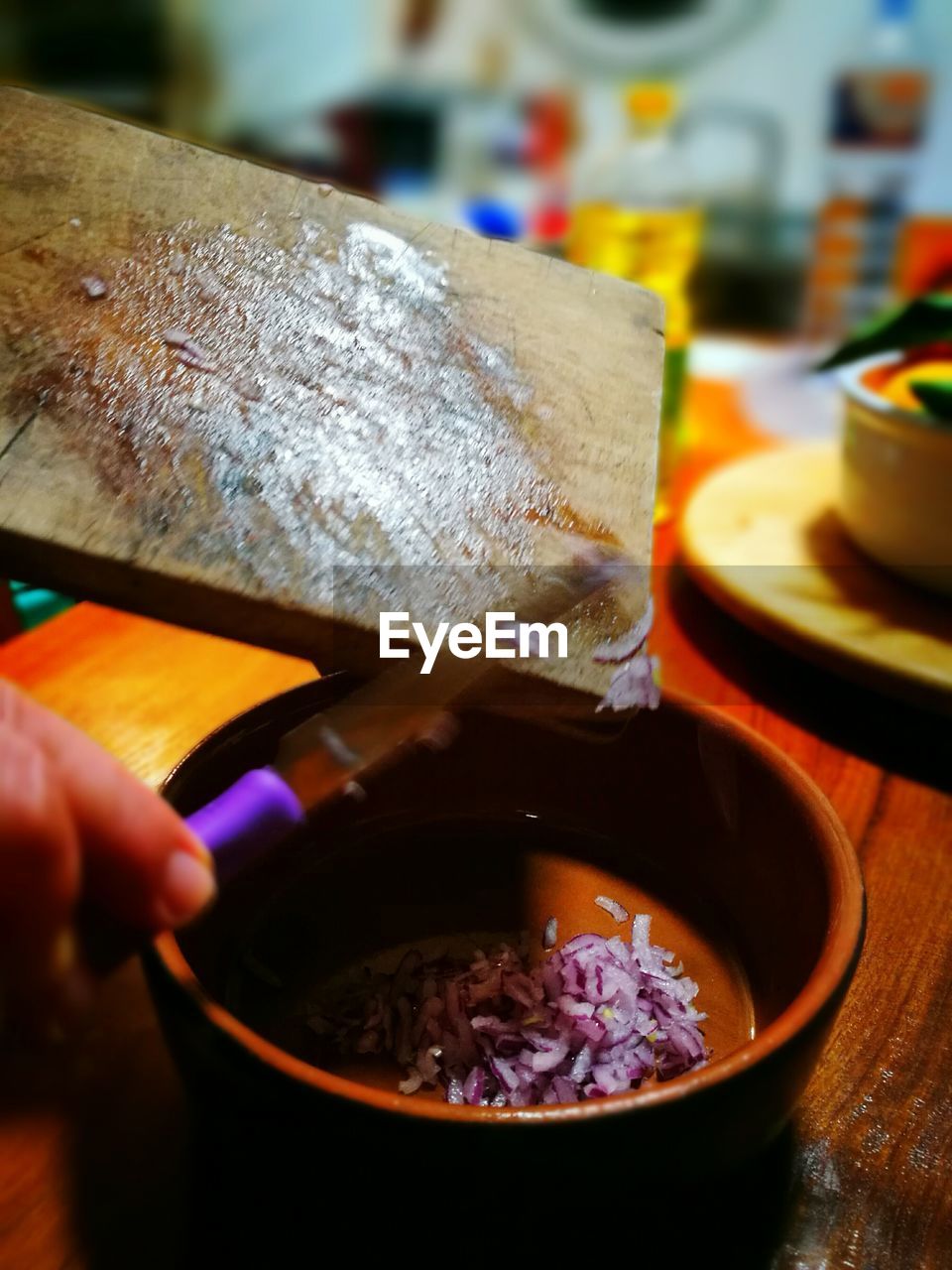 CLOSE-UP OF PERSON PREPARING FOOD IN KITCHEN