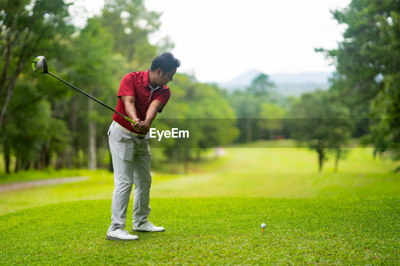 Full length of man playing golf at course