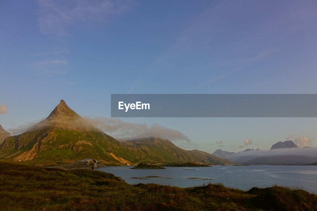SCENIC VIEW OF BAY AGAINST MOUNTAIN