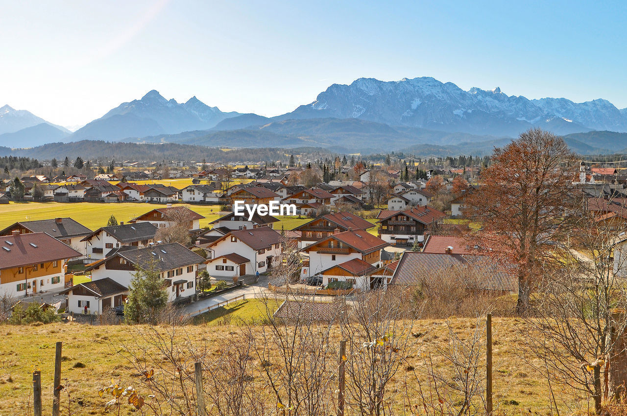 Residential district by mountains against sky