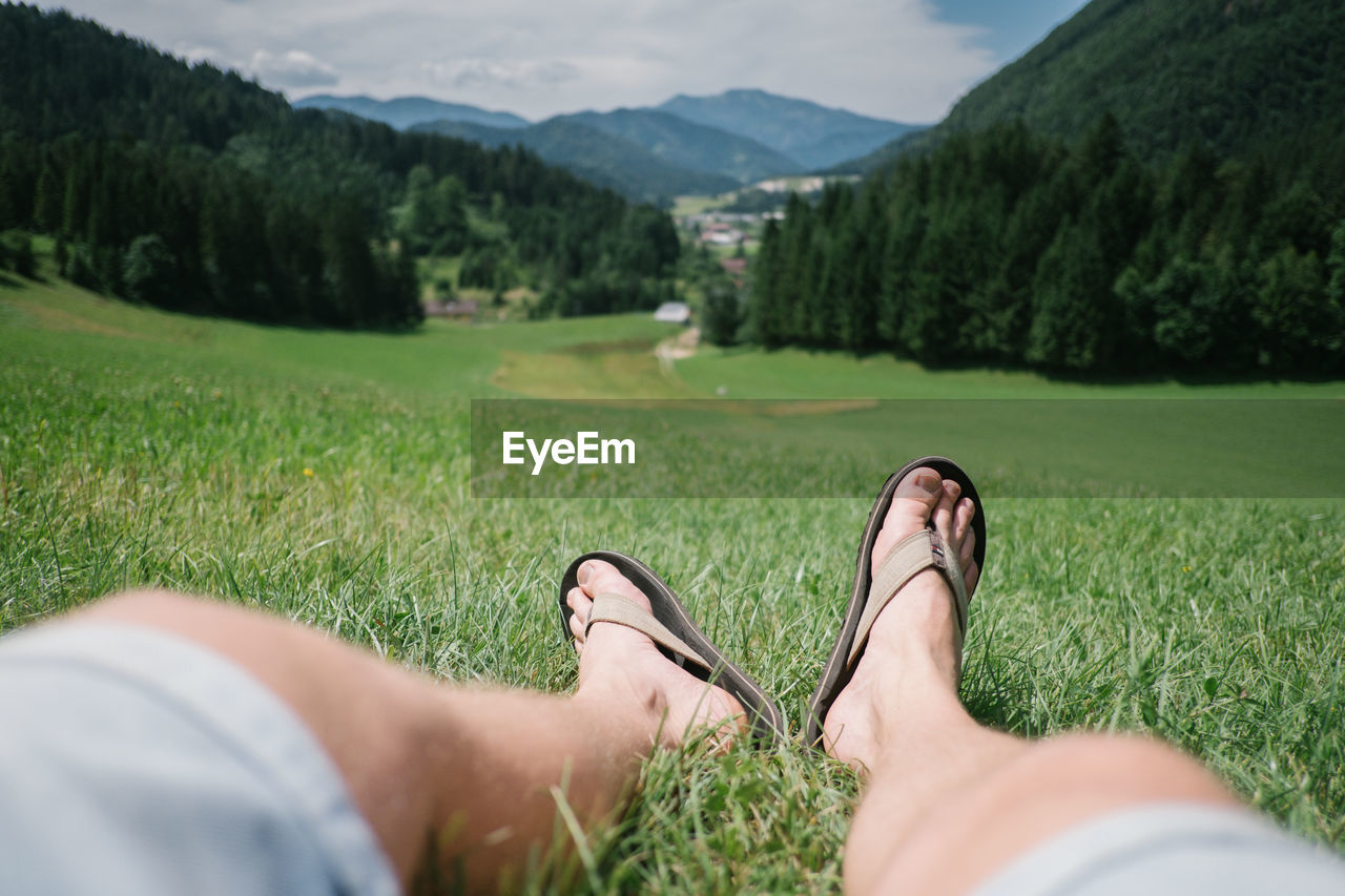 Low section of woman sitting on grassy field