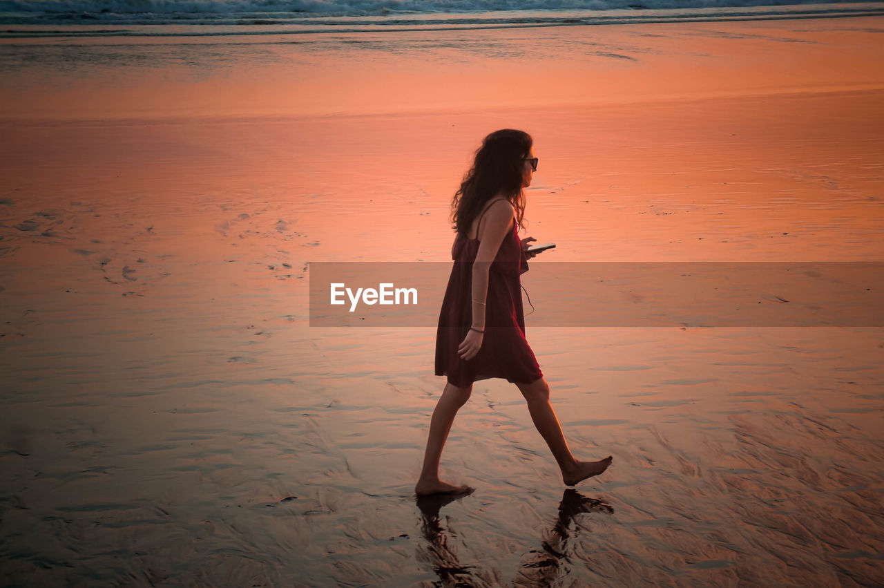 FULL LENGTH OF WOMAN STANDING ON BEACH