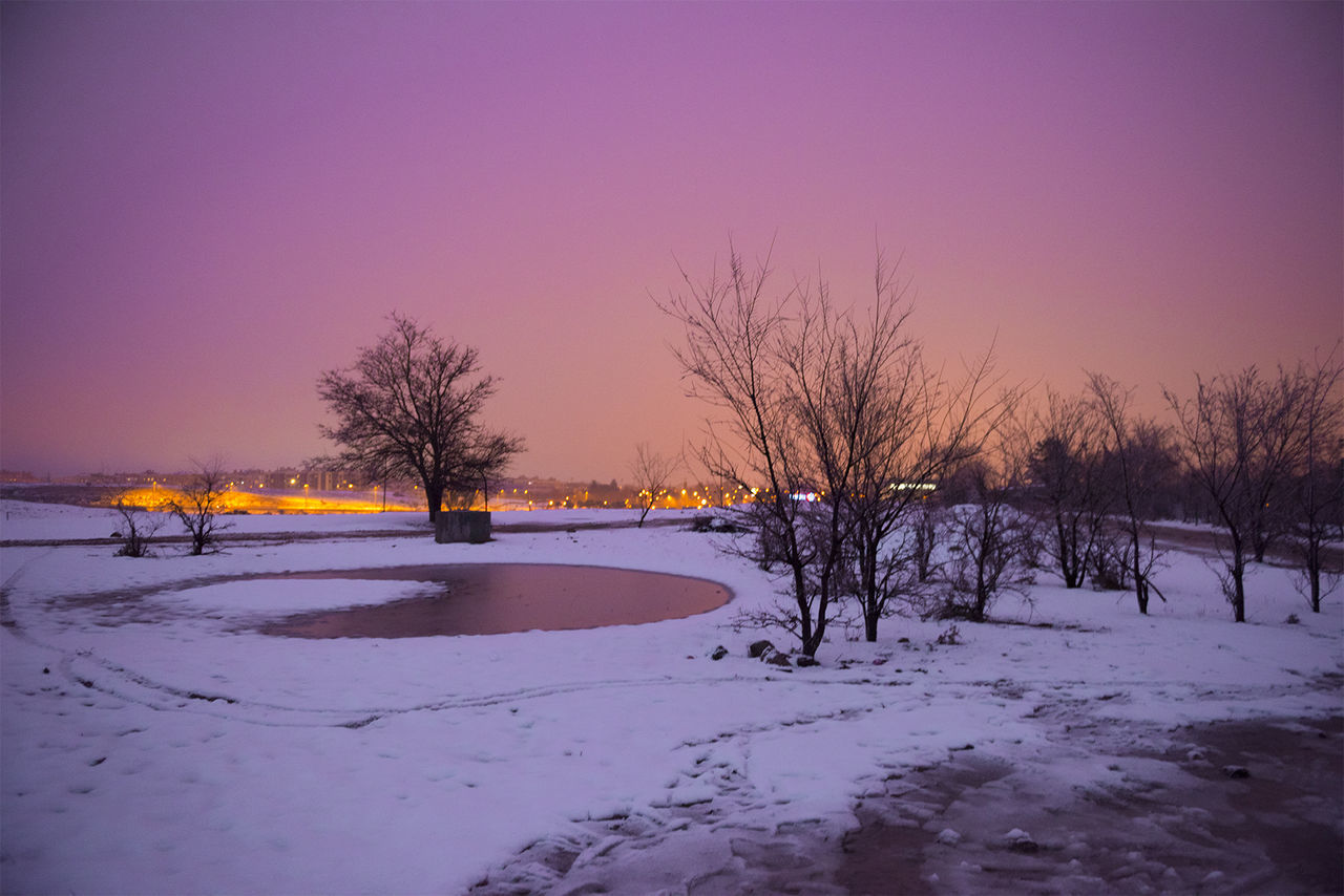 SNOW COVERED FIELD AGAINST SKY AT SUNSET