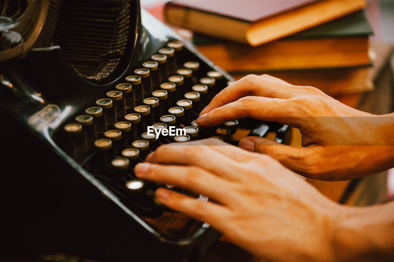 Cropped hands of man using typewriter