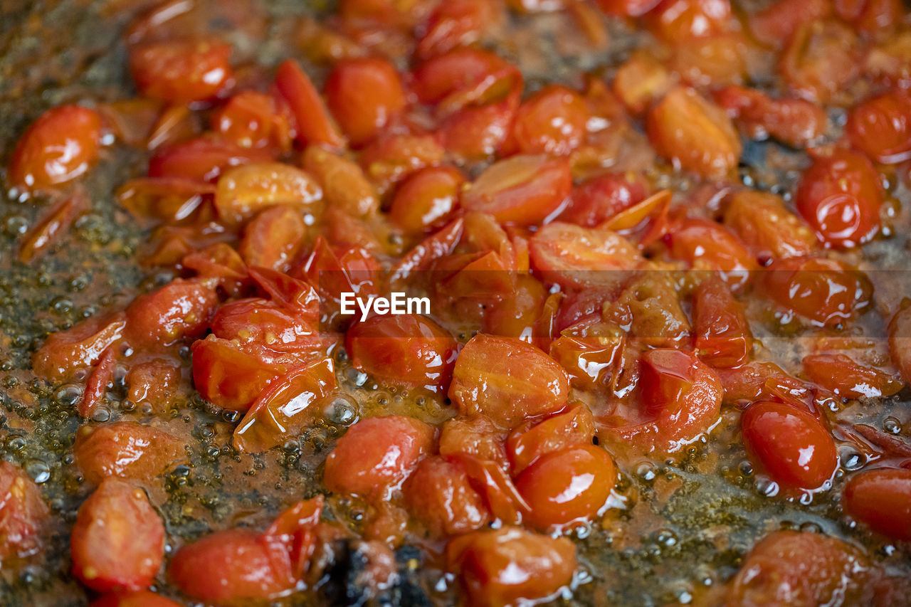 Cherry tomatoes frying in a pan with olive oil. 