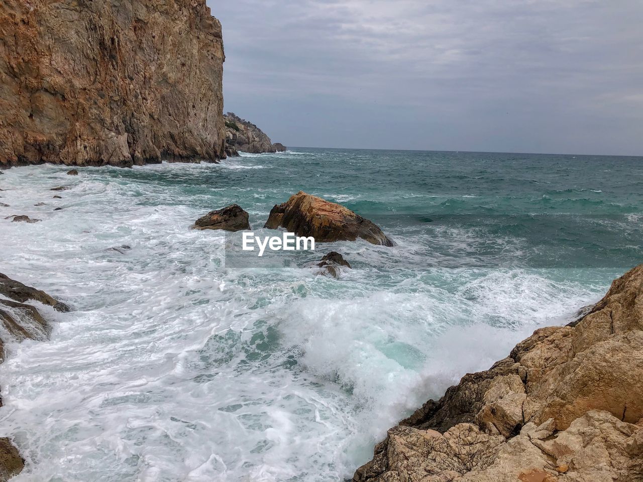 SCENIC VIEW OF ROCKS ON BEACH AGAINST SKY