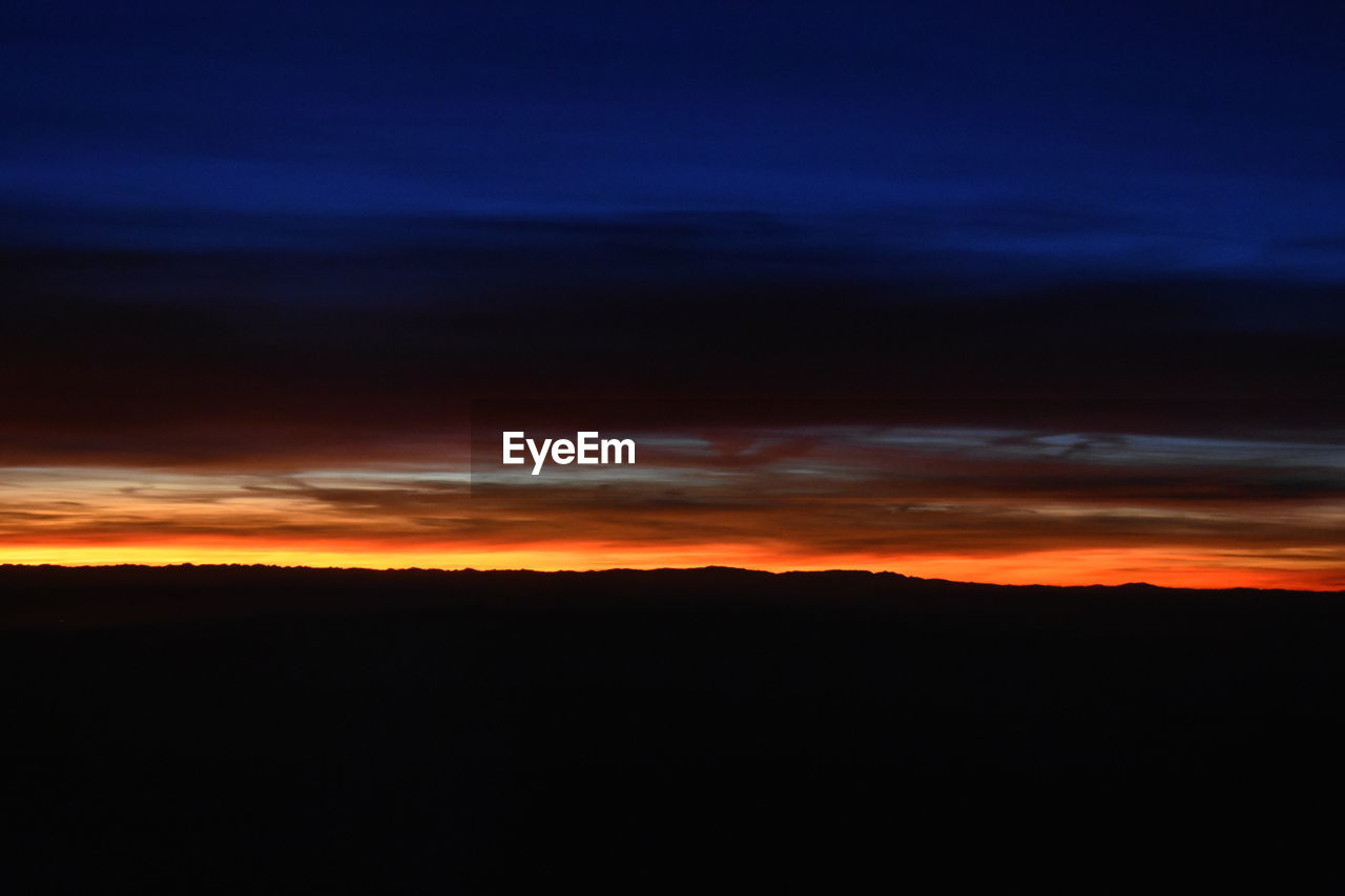 SCENIC VIEW OF SILHOUETTE LANDSCAPE AGAINST DRAMATIC SKY