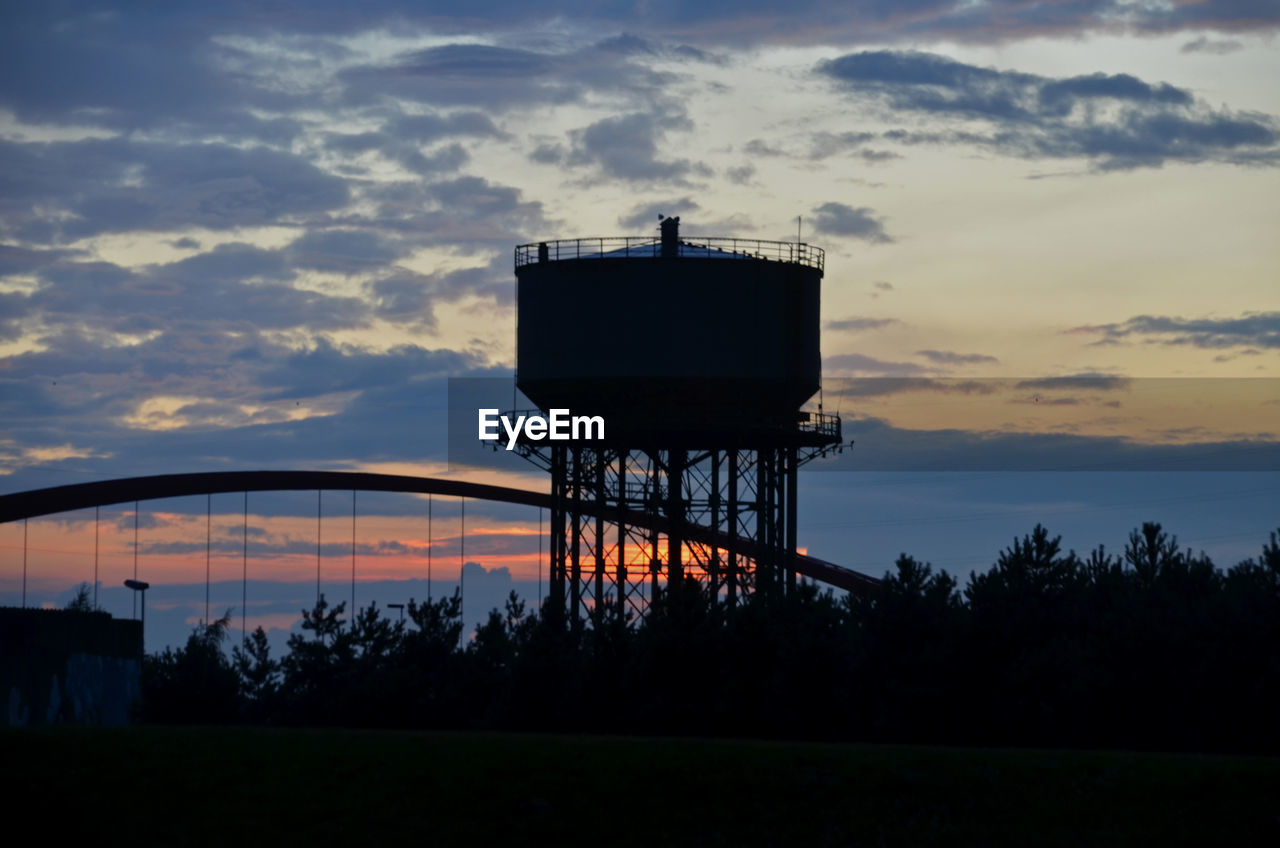 Silhouette water tower against sky at sunset