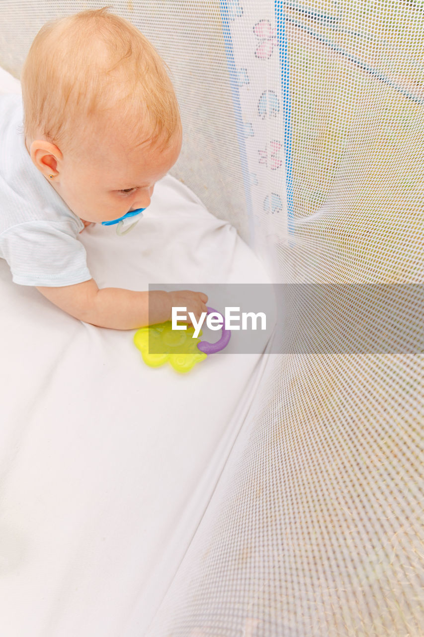 high angle view of baby girl lying on bed at home