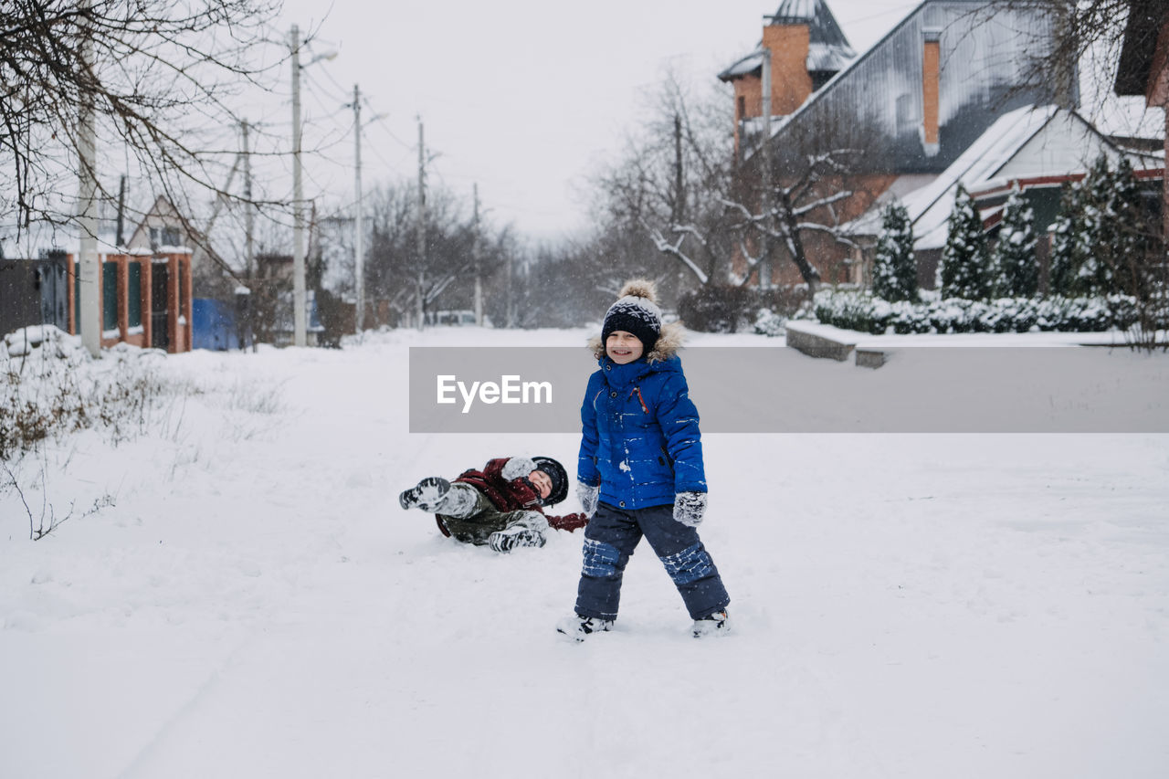 Outdoor winter activities for kids. kids playing in the suburbs, winter backyard gathering. boys