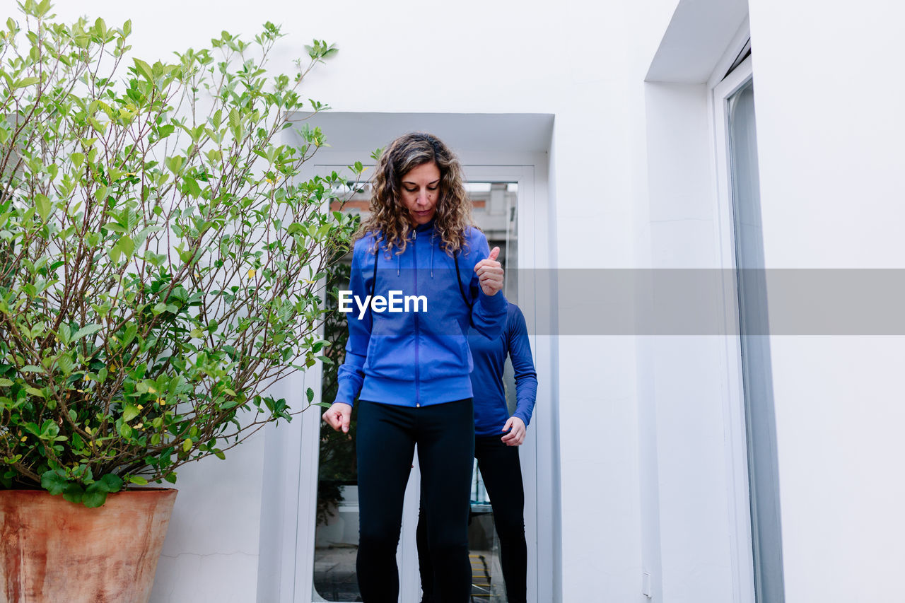 Woman standing by wall outdoors