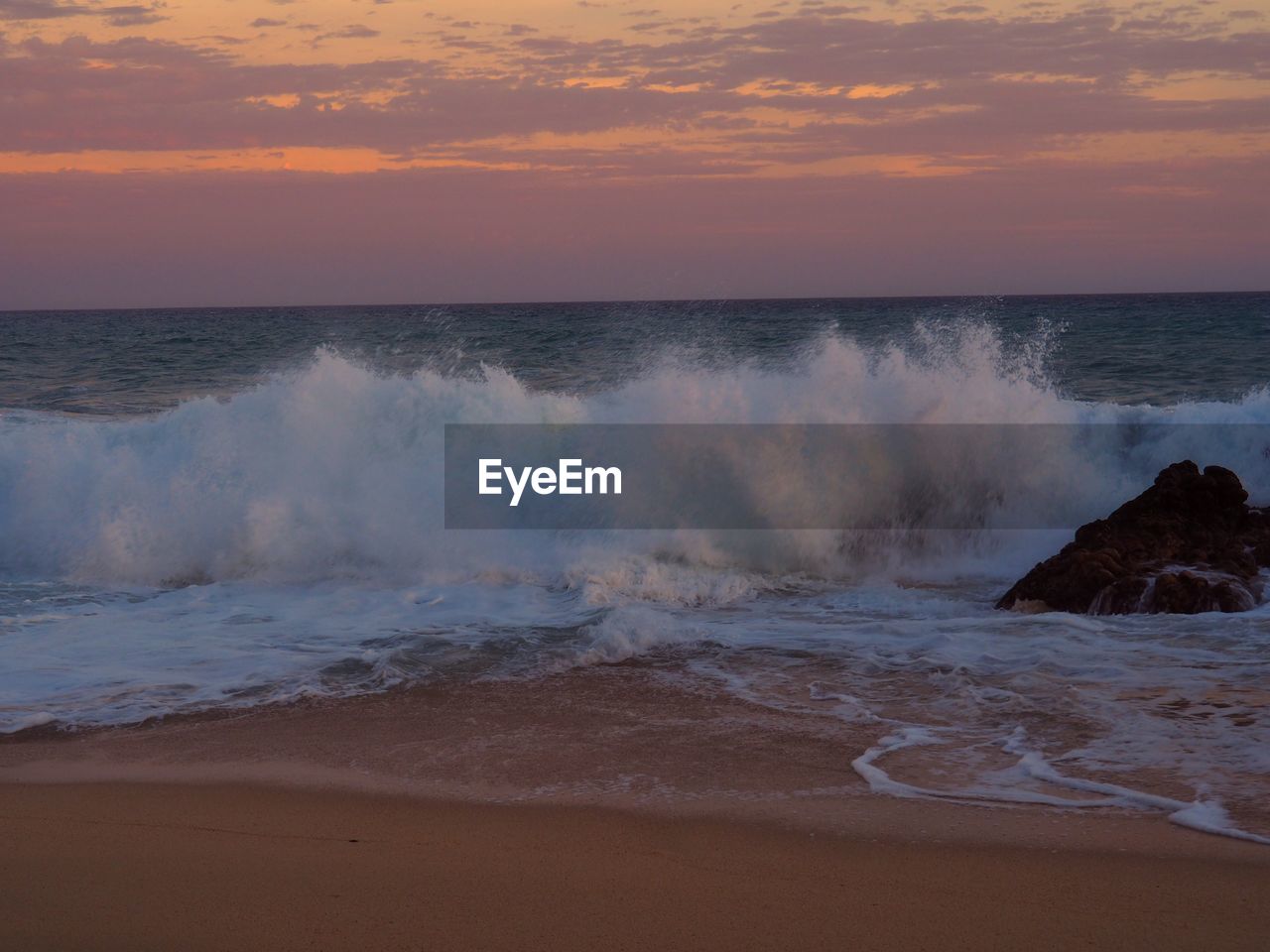 SCENIC VIEW OF SEA WAVES AGAINST SKY AT SUNSET