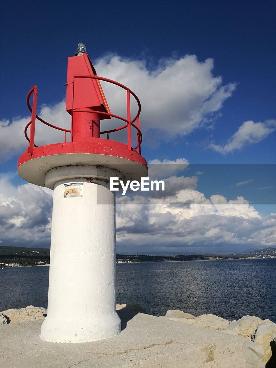 Lighthouse by sea against sky