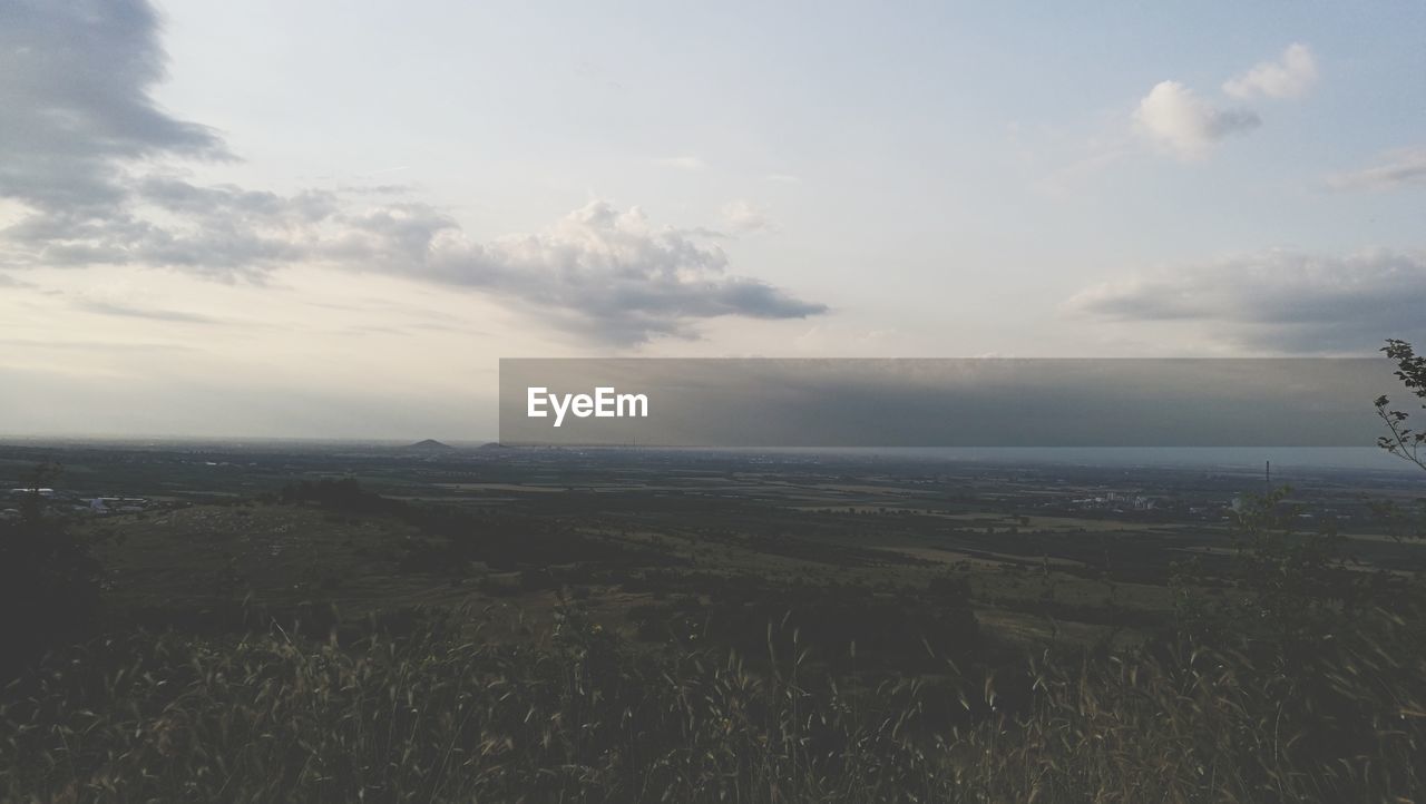 AERIAL VIEW OF AGRICULTURAL LANDSCAPE AGAINST SKY