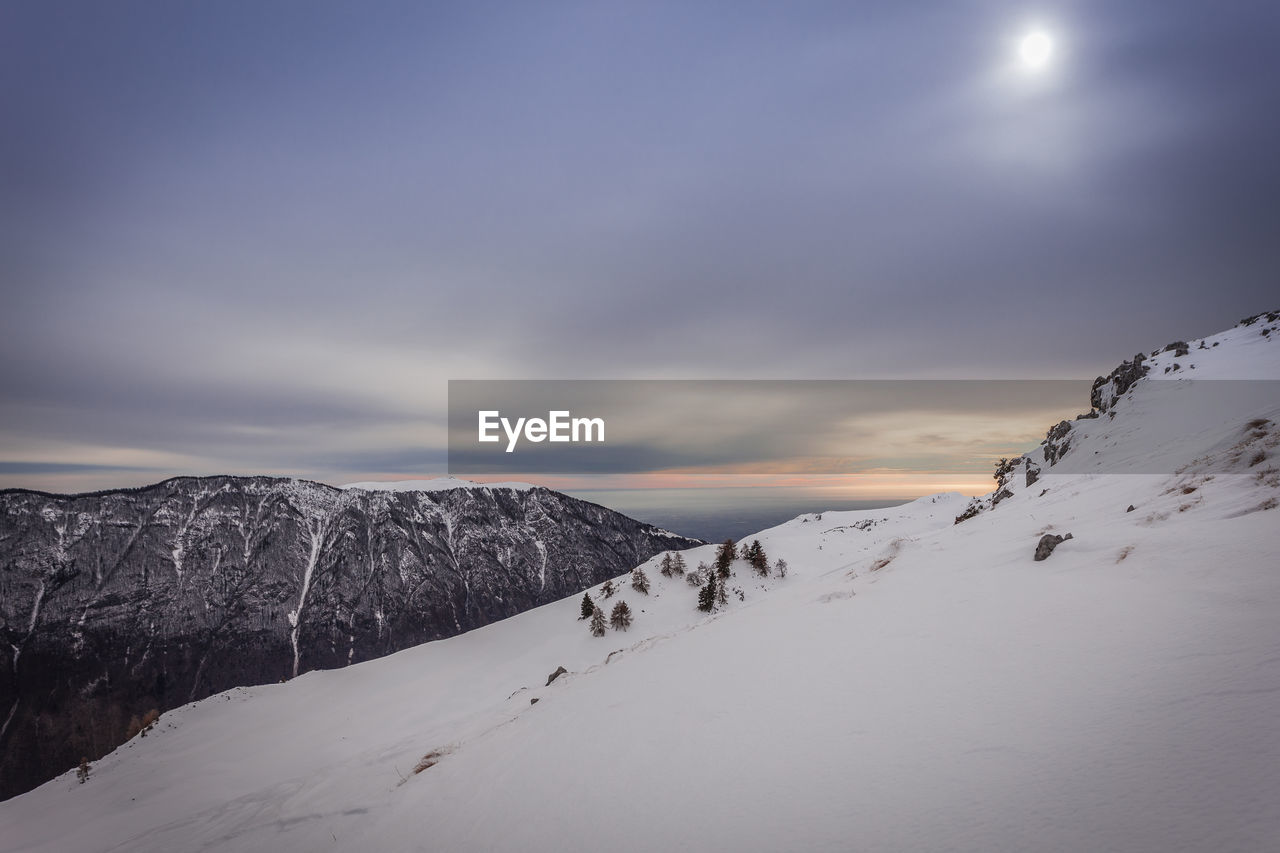 Scenic view of snow covered mountains against sky